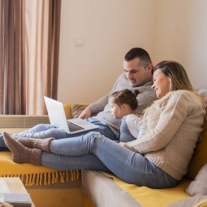 Young family on winter vacation, relaxing on the sofa